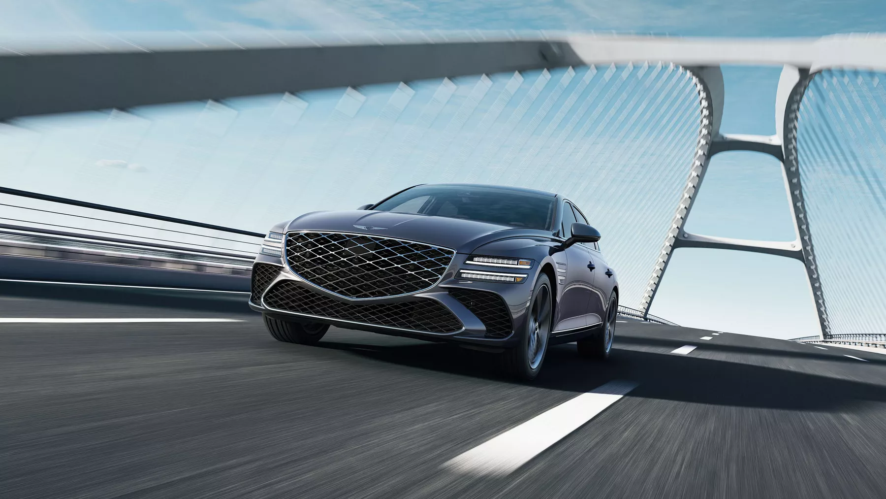 Low 7/8 front driver side view of Genesis G80 in Ceres Blue driving on suspension bridge