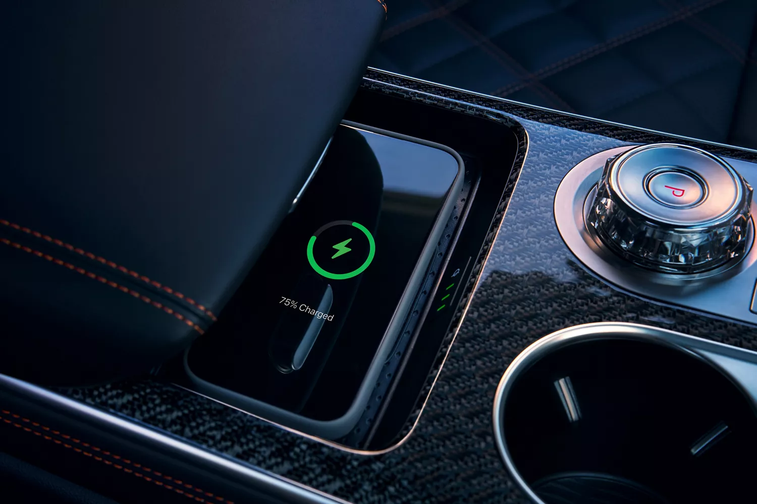 Close-up of a smartphone wirelessly charging in a car, displaying "75% Charged" and a green lightning bolt icon.